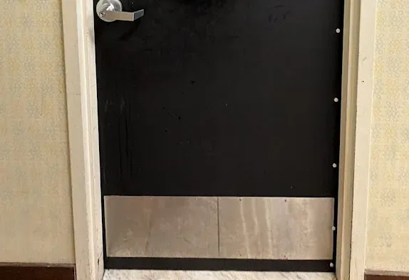 Black commercial entry door with lever hardware.