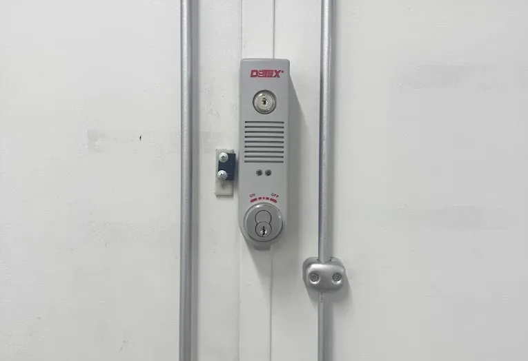 Vertical locking hardware on a metal commercial door.