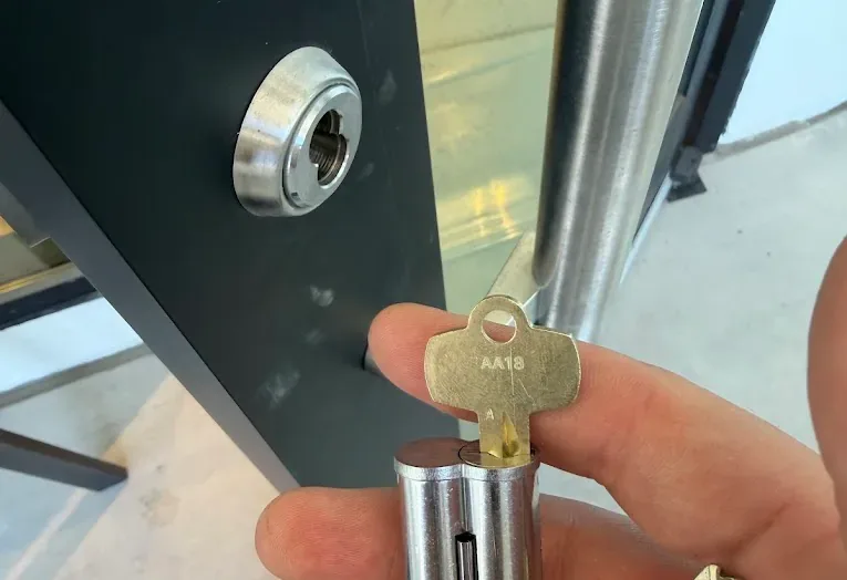 Key being turned in the cylinder of a commercial entry door.