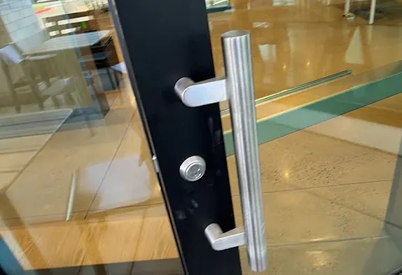 Digital keypad lock on a commercial glass door.