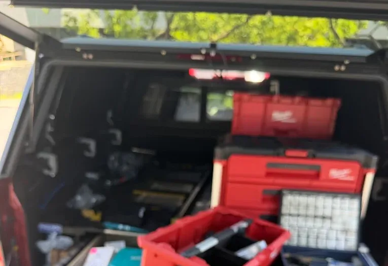 Locksmith tool cases and key pins arranged in an open service truck.