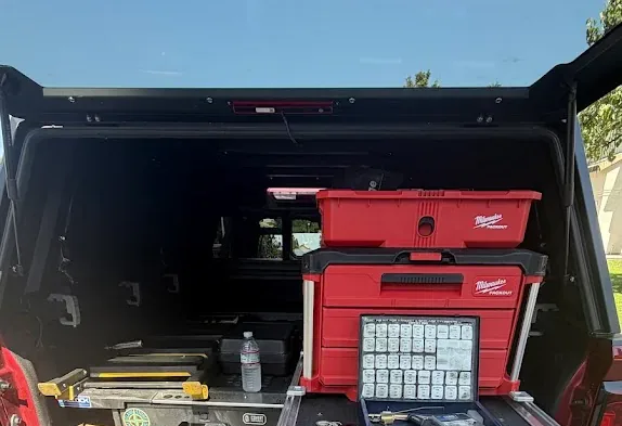 Locksmith key and pinning equipment arranged inside an open service truck.