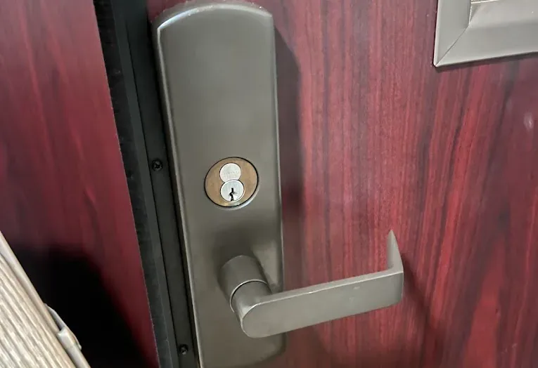 Deadbolt and lever on a red residential door.