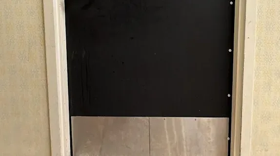 Black commercial entry door with lever hardware.