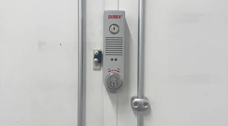 Vertical locking hardware on a metal commercial door.