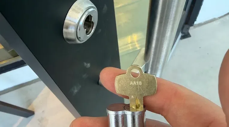 Key being turned in the cylinder of a commercial entry door.