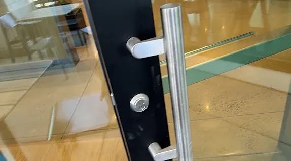 Digital keypad lock on a commercial glass door.
