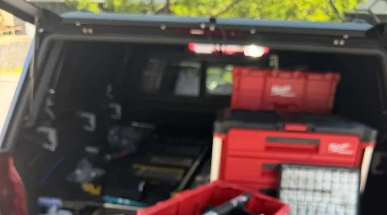 Locksmith tool cases and key pins arranged in an open service truck.