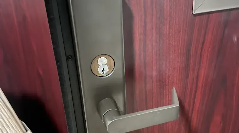 Deadbolt and lever on a red residential door.