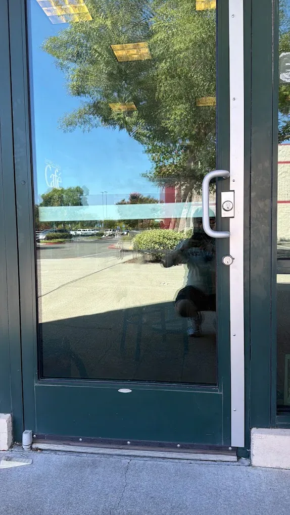 Exterior glass commercial door with a vertical handle.