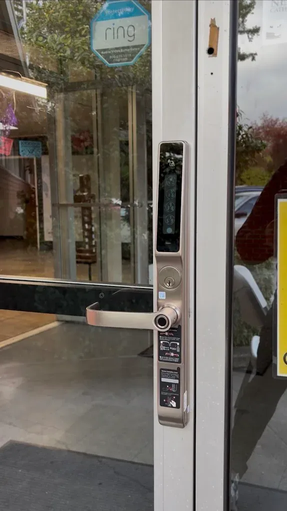 Access hardware mounted beside a commercial glass door.