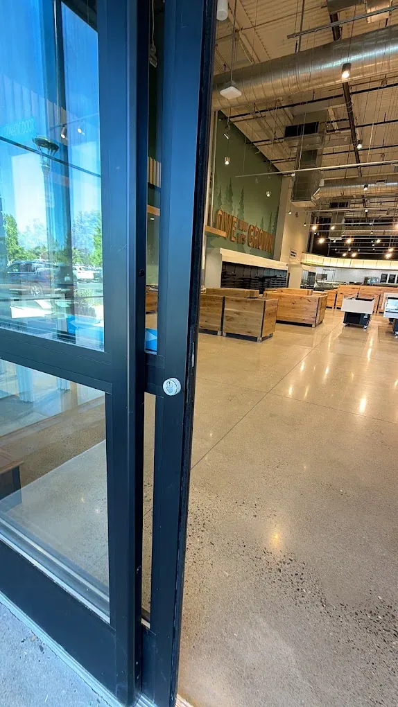 Close view of a metal lever handle on a glass commercial door.