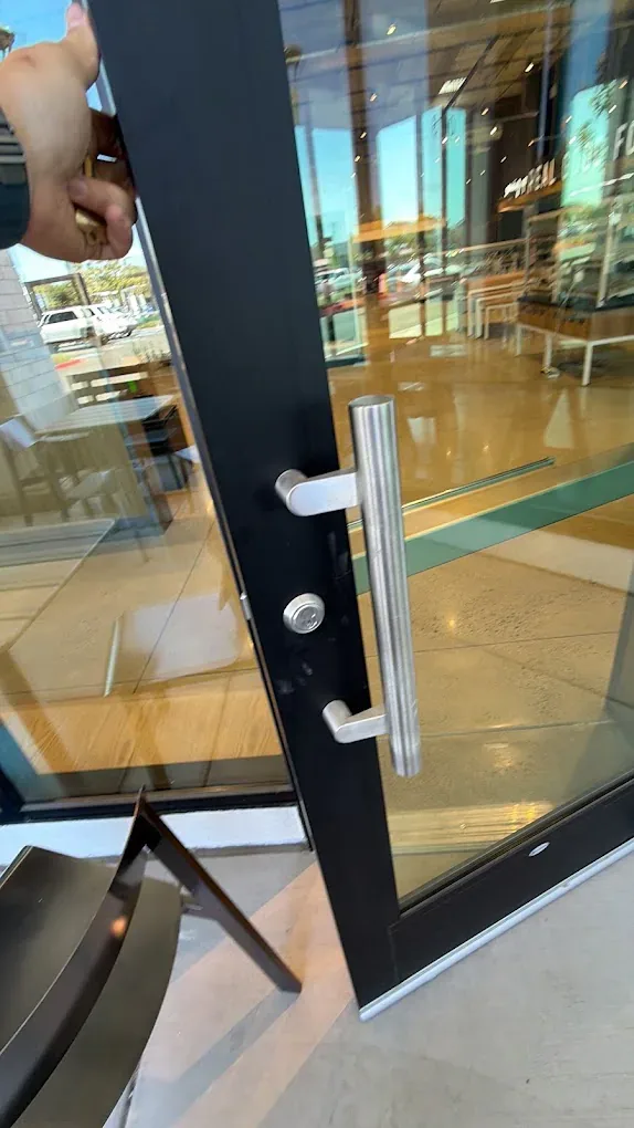 Digital keypad lock on a commercial glass door.