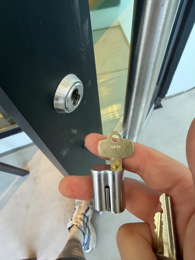 Key being turned in the cylinder of a commercial entry door.