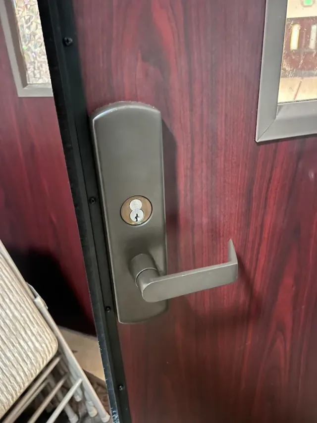 Deadbolt and lever on a red residential door.