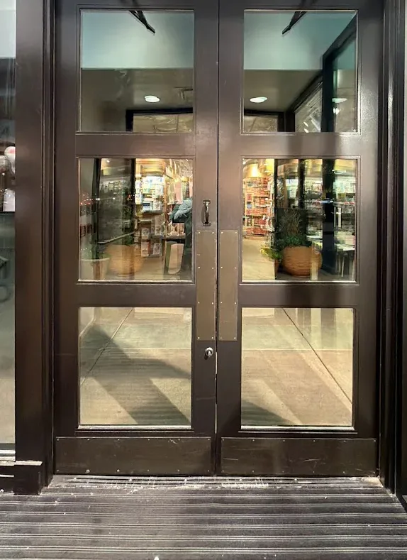 Dark metal-framed double entry doors viewed from outside.